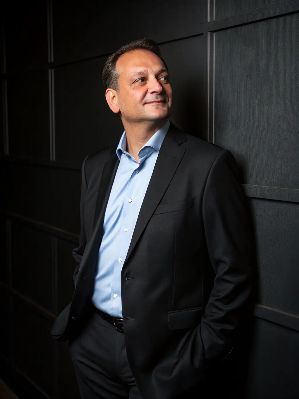 A professional headshot of a smiling South African director, showcasing success and leadership.